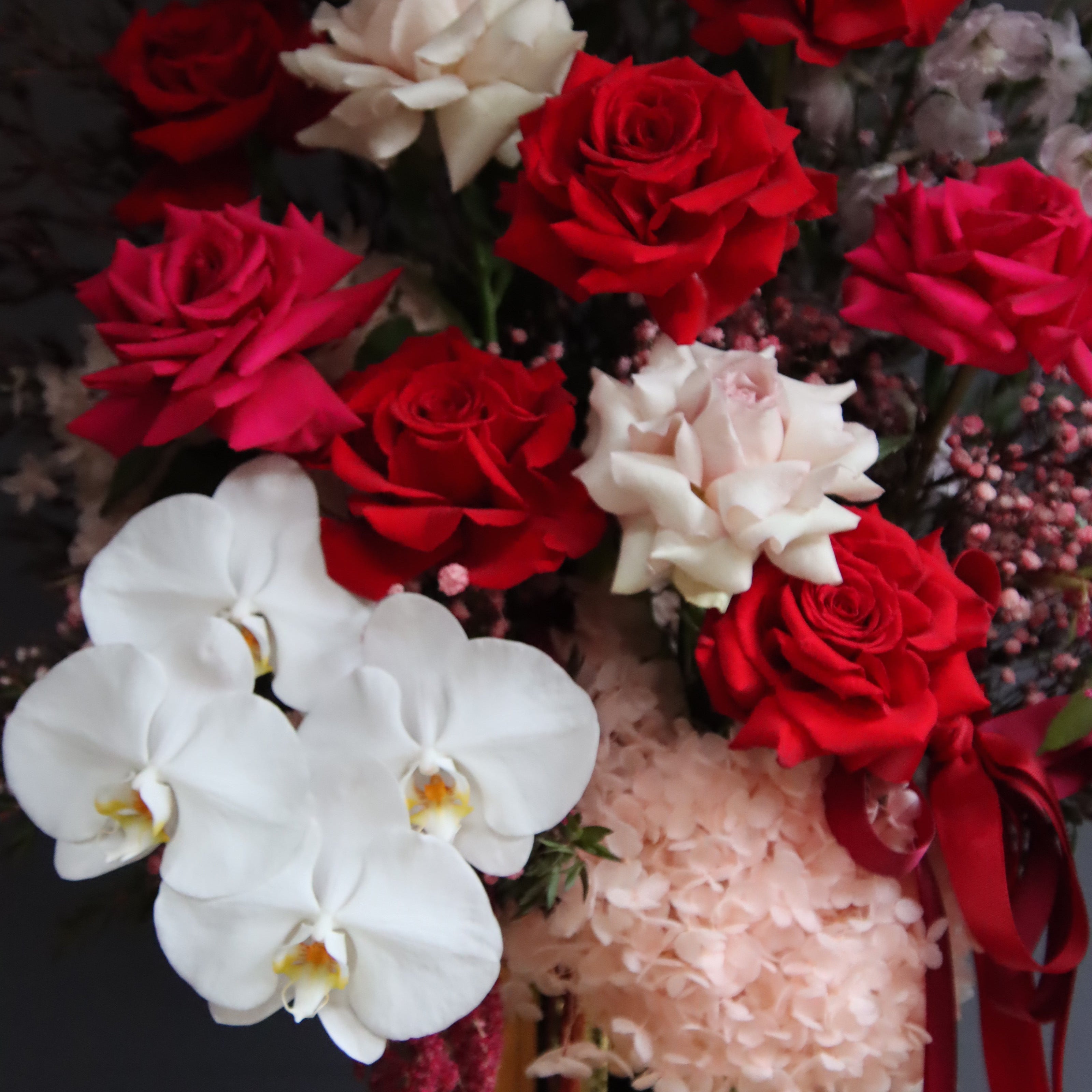 Grand reflexed rose and orchid arrangement in gold glass pot – Ruby by Ivy & Twig Florist